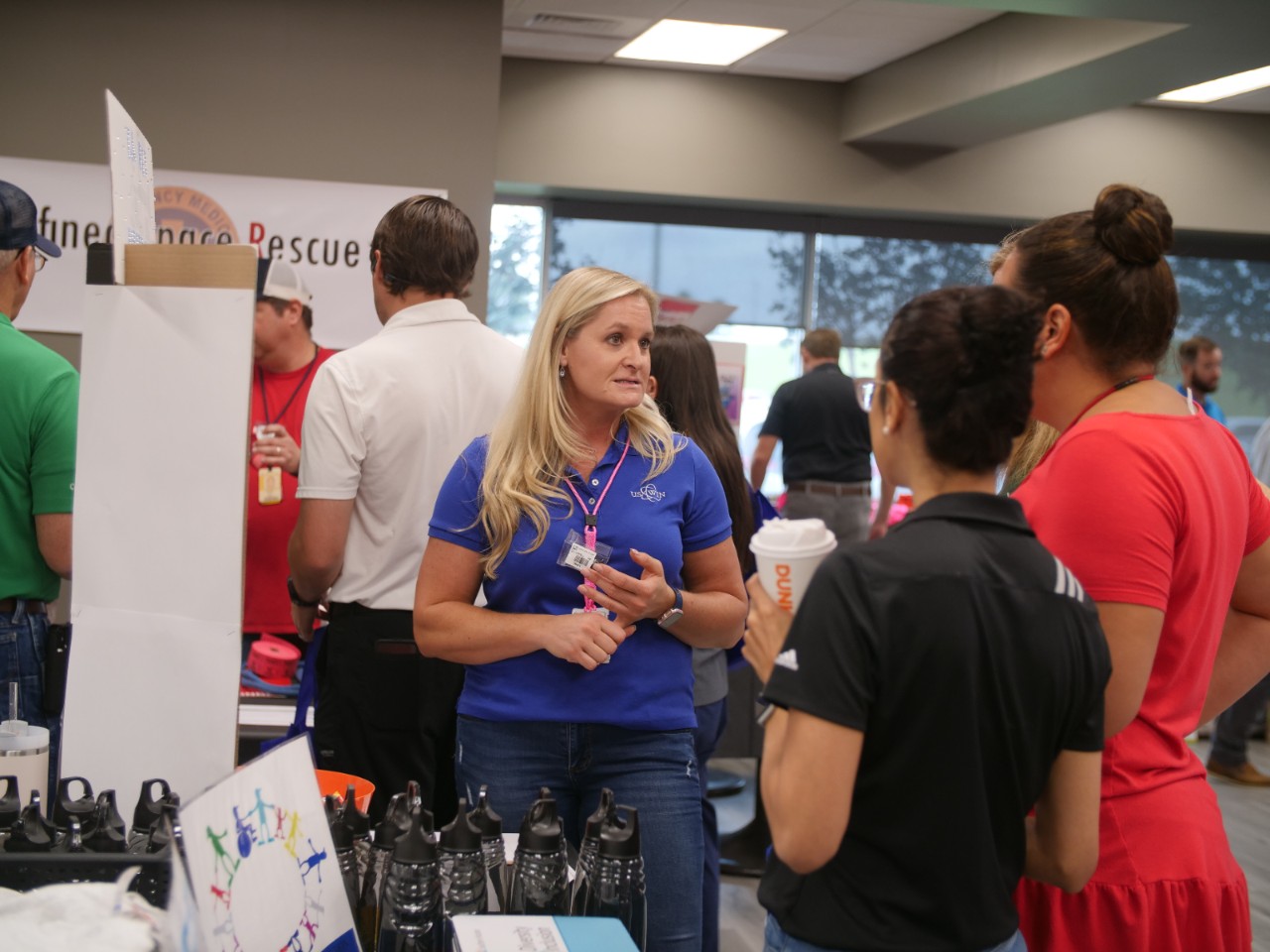 A Southern Nuclear employee engages in conversation with colleagues during a workplace culture event, surrounded by informational booths and displays.
