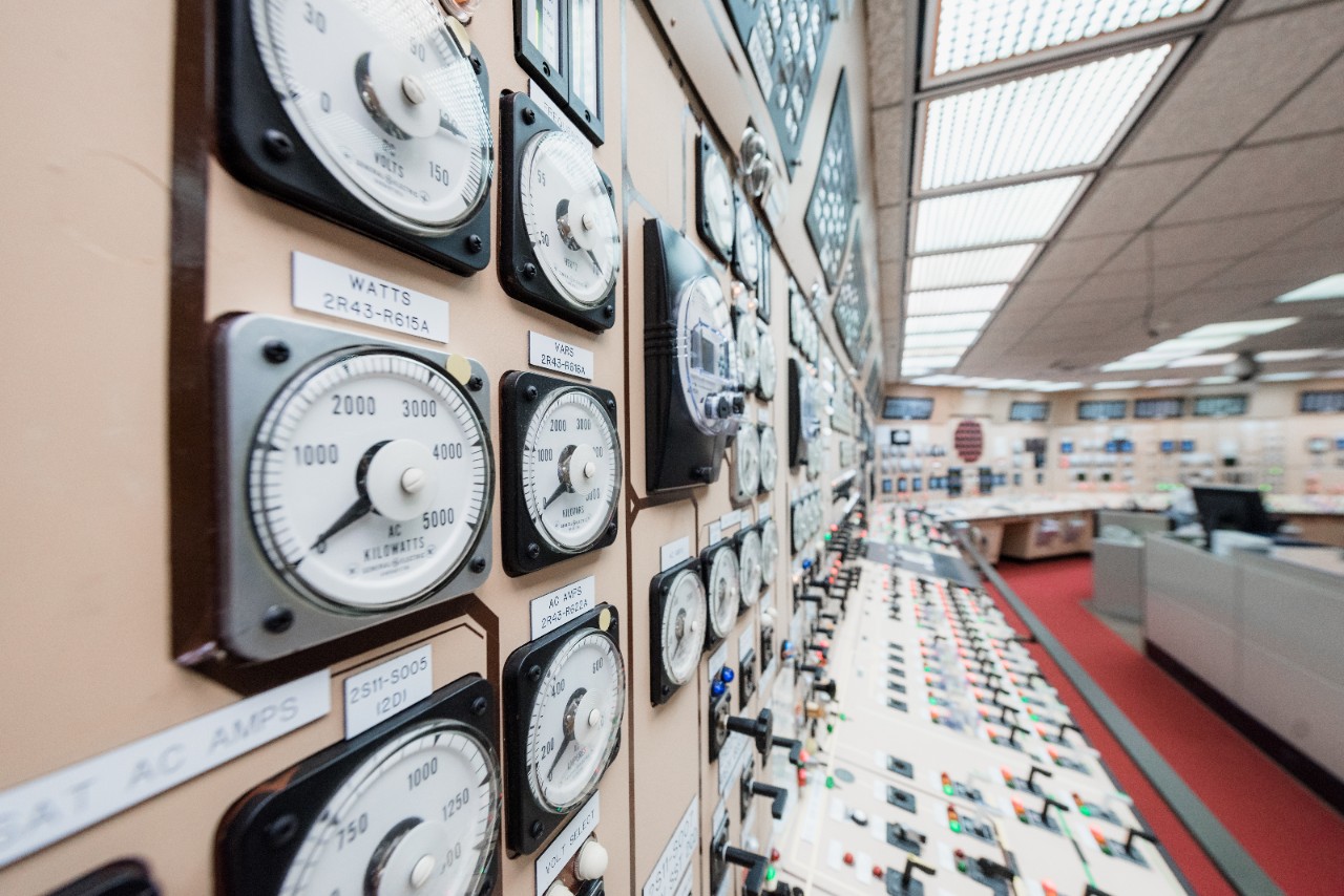 Analog meters and controls line a simulated control room, illustrating legacy infrastructure in the evolution of nuclear energy technology.
