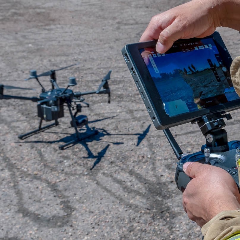 A person operates a drone via tablet, showcasing how Southern Nuclear uses drone surveillance in nuclear energy innovation and safety checks.
